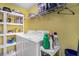 A functional laundry room with white washer and dryer, storage shelves, and yellow walls creating a bright space at 340 Nail Rd, Mcdonough, GA 30253