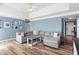 Comfortable living room featuring a large gray sectional sofa, stylish decor, and abundant natural light at 340 Nail Rd, Mcdonough, GA 30253