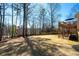 Large backyard with a mix of grass and trees, offering ample space for recreation and leisure at 5383 Fawn Meadow Ln, Powder Springs, GA 30127