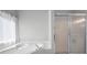 Bright bathroom featuring a shower with sliding glass doors and garden tub under a window at 5383 Fawn Meadow Ln, Powder Springs, GA 30127