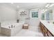 Large bathroom features a garden tub, tiled floors, double sinks and a window at 828 Guinevere Sw Way, Lilburn, GA 30047