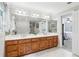 Large bathroom features tile floors, double sinks with vanities, a large mirror, and a window at 828 Guinevere Sw Way, Lilburn, GA 30047
