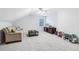 Bright bonus room with a neutral color palette, plush carpet, and a cozy sofa at 828 Guinevere Sw Way, Lilburn, GA 30047