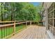 Wooden deck with black railings, white trim, and backyard trees at 828 Guinevere Sw Way, Lilburn, GA 30047