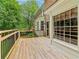 Wooden deck with railing on a brick home overlooking a green lawn and trees at 828 Guinevere Sw Way, Lilburn, GA 30047