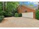 Side view of brick house showing garage with basketball hoop and driveway at 828 Guinevere Sw Way, Lilburn, GA 30047
