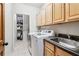 Well-equipped laundry room with modern washer, dryer, sink, and storage cabinets at 828 Guinevere Sw Way, Lilburn, GA 30047