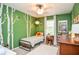 Fun bedroom with bright green walls, decorative tree decals, and natural light from the window at 1438 Ridgeland Sw Ct, Lilburn, GA 30047