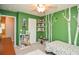 Adorable room features whimsical forest mural, ceiling fan, and built-in shelving for books and toys at 1438 Ridgeland Sw Ct, Lilburn, GA 30047