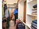 Organized walk-in closet featuring multiple shelves, hanging rods, and ample storage space for clothes and accessories at 1438 Ridgeland Sw Ct, Lilburn, GA 30047