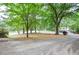 Driveway with mature trees lining the front yard at 1438 Ridgeland Sw Ct, Lilburn, GA 30047