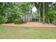 Charming two-story home with mature trees and a lush, green lawn and beautiful bark-covered front yard at 1438 Ridgeland Sw Ct, Lilburn, GA 30047