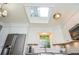 Bright kitchen with skylight, white cabinets, granite countertops, and stainless steel appliances at 1438 Ridgeland Sw Ct, Lilburn, GA 30047