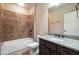Bathroom featuring a tiled shower and a vanity with granite countertop and dark wood cabinets at 1655 Dawn Dr, Suwanee, GA 30024