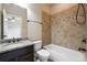 Bathroom with vanity, toilet, tub, and tile surround at 1655 Dawn Dr, Suwanee, GA 30024