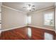 Bedroom with hardwood flooring, two windows, ceiling fan, neutral walls, and white trim at 1655 Dawn Dr, Suwanee, GA 30024