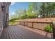 Large wooden deck with dark railing overlooks lush green landscaping and blooming azaleas at 1655 Dawn Dr, Suwanee, GA 30024
