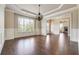 Dining room featuring hardwood floors, chair railing, crown molding, and a chandelier at 1655 Dawn Dr, Suwanee, GA 30024