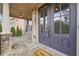 Close-up of front door and porch with stone accents, a welcome mat, and hanging lights at 1655 Dawn Dr, Suwanee, GA 30024