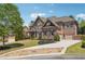 Sprawling brick and stone home with an attached three car garage and a paver driveway at 1655 Dawn Dr, Suwanee, GA 30024