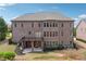 Rear exterior of a large two story home with a deck and a covered patio at 1655 Dawn Dr, Suwanee, GA 30024