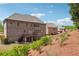 Backyard view of a large brick house with a deck and landscaped hillside at 1655 Dawn Dr, Suwanee, GA 30024