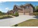 Exterior view of a brick home featuring a three-car garage and a paved driveway with grass lawn at 1655 Dawn Dr, Suwanee, GA 30024