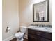 Cozy powder room features a granite vanity top and a decorative mirror at 1655 Dawn Dr, Suwanee, GA 30024