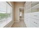 Spacious walk-in closet featuring large window with blinds, carpet floor, and built-in shelving with drawers at 1655 Dawn Dr, Suwanee, GA 30024