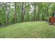Large, green backyard bordered by a lush forest, offering privacy and natural beauty at 5500 Georgetown Sw Trce, Lilburn, GA 30047