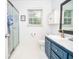 Bathroom featuring a glass enclosed shower, white tile floors, and a vanity with ample counter space at 5500 Georgetown Sw Trce, Lilburn, GA 30047