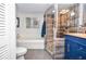 Modern bathroom with a glass-enclosed shower, luxurious tub, and stylish blue vanity at 5500 Georgetown Sw Trce, Lilburn, GA 30047