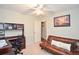 This bedroom has a ceiling fan, plush carpet, a futon, and a desk with office storage at 5500 Georgetown Sw Trce, Lilburn, GA 30047