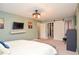 Spacious bedroom with en suite closet, light green walls, and a mounted TV for entertainment at 5500 Georgetown Sw Trce, Lilburn, GA 30047