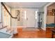 Inviting entryway with hardwood floors, white door, decorative mirror, and staircase with painted risers and banister at 5500 Georgetown Sw Trce, Lilburn, GA 30047