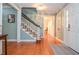 Bright foyer with hardwood floors, staircase, white front door, elegant lighting and access to other rooms at 5500 Georgetown Sw Trce, Lilburn, GA 30047