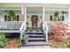 Inviting front porch with decorative plants and an American flag at 5500 Georgetown Sw Trce, Lilburn, GA 30047