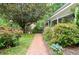 Landscaped brick walkway leading to a charming home with lush greenery at 5500 Georgetown Sw Trce, Lilburn, GA 30047