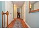 Bright hallway with hardwood floors, an area rug, and open doorways to bedrooms, exuding a comfortable ambiance at 5500 Georgetown Sw Trce, Lilburn, GA 30047