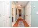Light-filled hallway with hardwood floors, a patterned rug, and neutral paint, creating a welcoming path at 5500 Georgetown Sw Trce, Lilburn, GA 30047