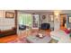 Inviting living room with hardwood floors, opens to a screened porch, and has a bright, colorful rug at 5500 Georgetown Sw Trce, Lilburn, GA 30047