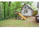 Backyard playhouse featuring a slide, tire swing, and climbing structure at 5500 Georgetown Sw Trce, Lilburn, GA 30047