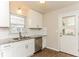 Bright kitchen featuring white cabinets, granite counters, a stainless steel dishwasher, and a backyard view at 3588 Swallow Ln, Decatur, GA 30032