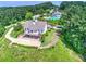 Aerial view of a home with a large drive and deck in wooded, green area, with community pool and clubhouse at 111 Carter Ln, Canton, GA 30115