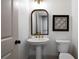 Powder room features a pedestal sink, decorative mirror, and stylish fixtures at 111 Carter Ln, Canton, GA 30115