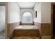 Relaxing bathtub with tile surround and natural light from the arched window at 111 Carter Ln, Canton, GA 30115
