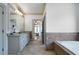 Spacious bathroom featuring dual sink vanity, granite countertop, and tiled tub at 111 Carter Ln, Canton, GA 30115