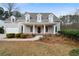 Charming two-story home with a covered front porch, dormer windows, and a well-maintained landscaped yard at 111 Carter Ln, Canton, GA 30115