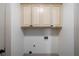 Laundry room with beige cabinets with black hardware and white walls at 111 Carter Ln, Canton, GA 30115