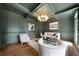 Stylish living room with dark green walls, coffered ceiling, hardwood floors, and elegant furnishings at 111 Carter Ln, Canton, GA 30115